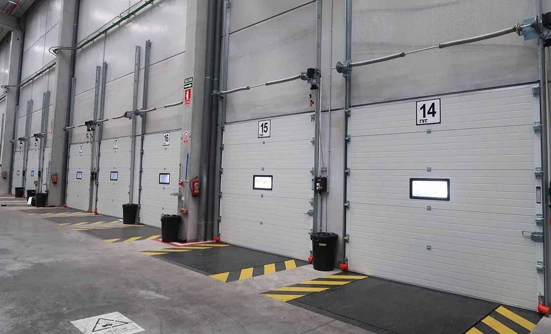 Vertical lift sectional door tracks maximizing warehouse interior overhead space.