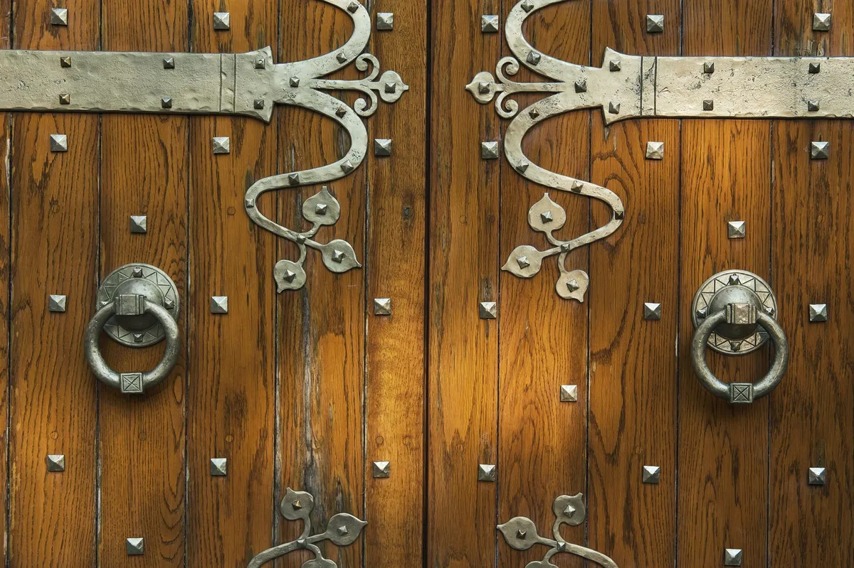 Detailed view of an automatic drop-down threshold mechanism and compression jamb seals installed on a door.