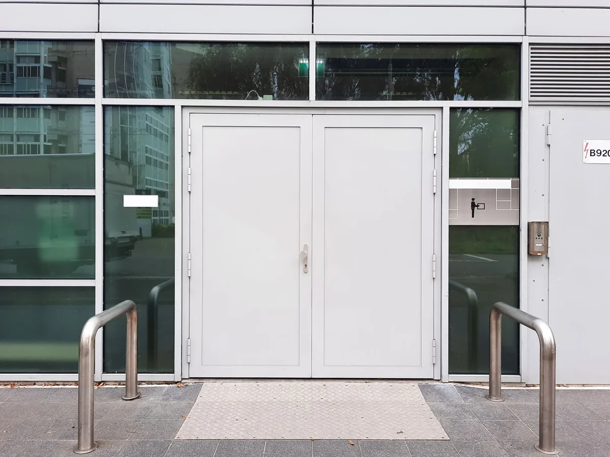 Front view of a modern industrial glass building entrance with double doors