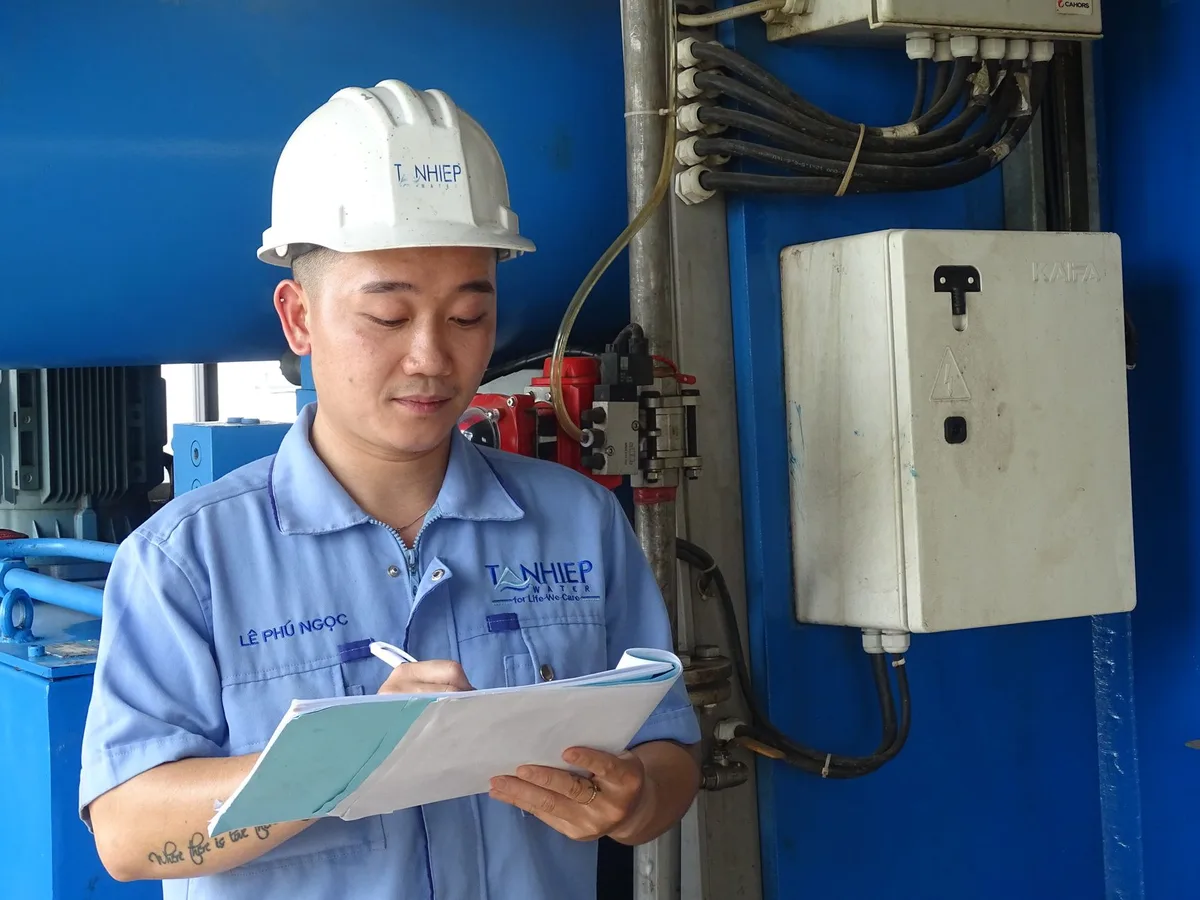 Ingeniero de mantenimiento de instalaciones de sala blanca inspeccionando bisagras ocultas de puerta y juntas de caída