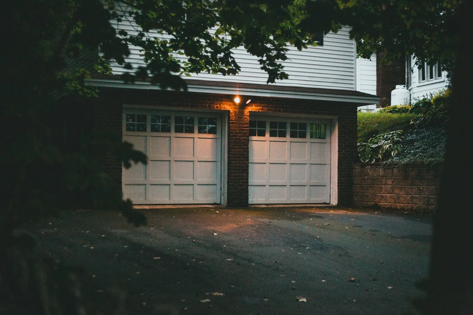 Luxury residential villa with premium automated belt-drive sectional garage door illuminated in the evening