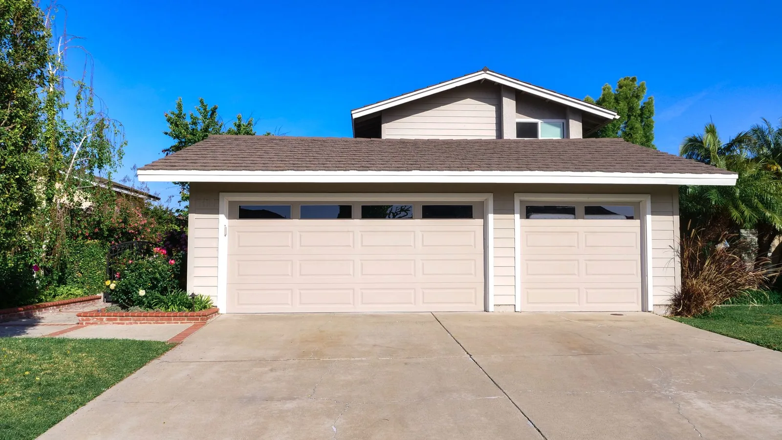 Contemporary suburban home featuring automated sectional garage door and modern driveway