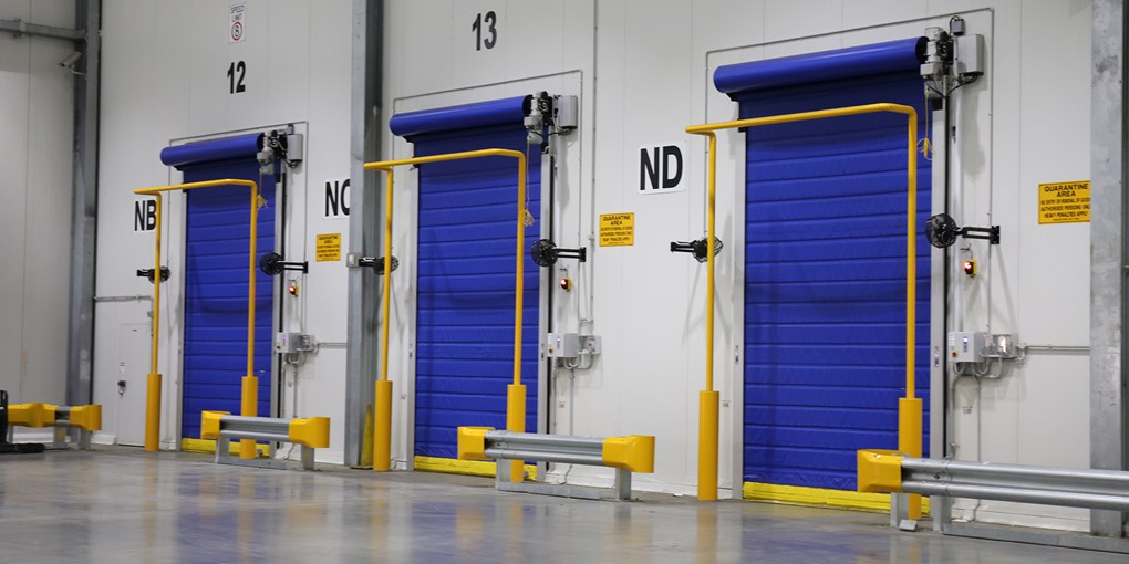 Insulated aluminum high speed door separating a cold storage area from a standard warehouse environment.