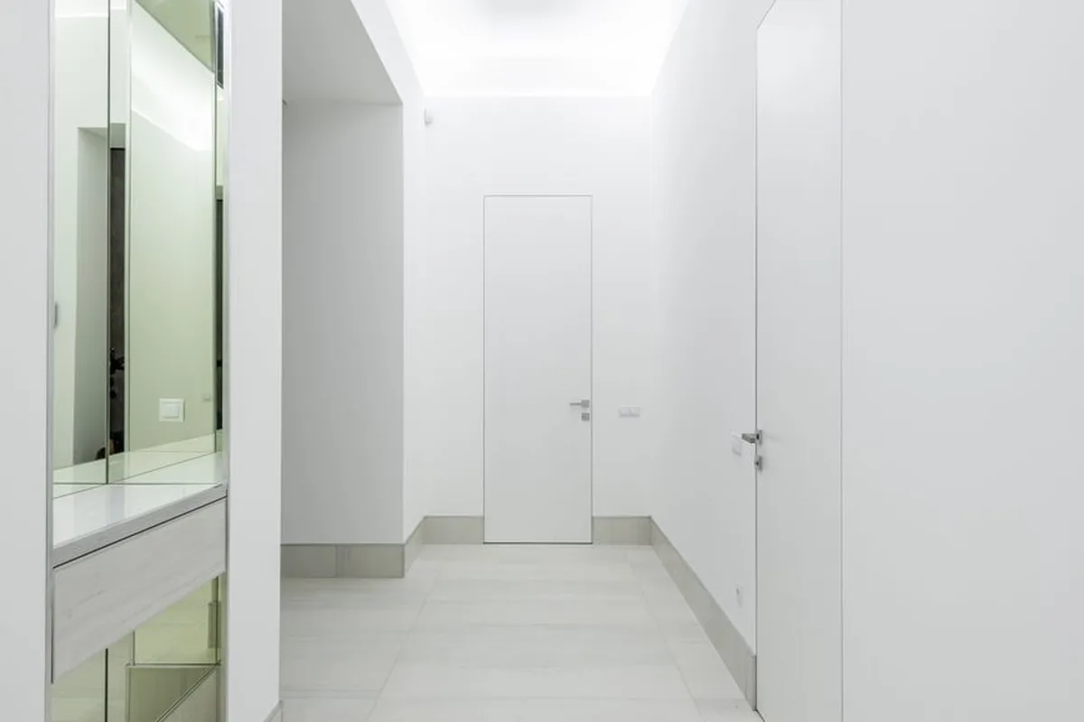 Cleanroom door frame anchored flush within modular sandwich partition walls at the opening