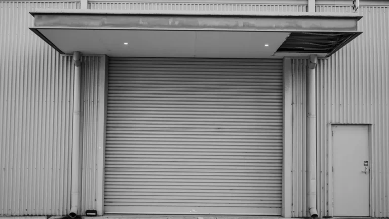 Large grey industrial roller shutter door on a warehouse wall