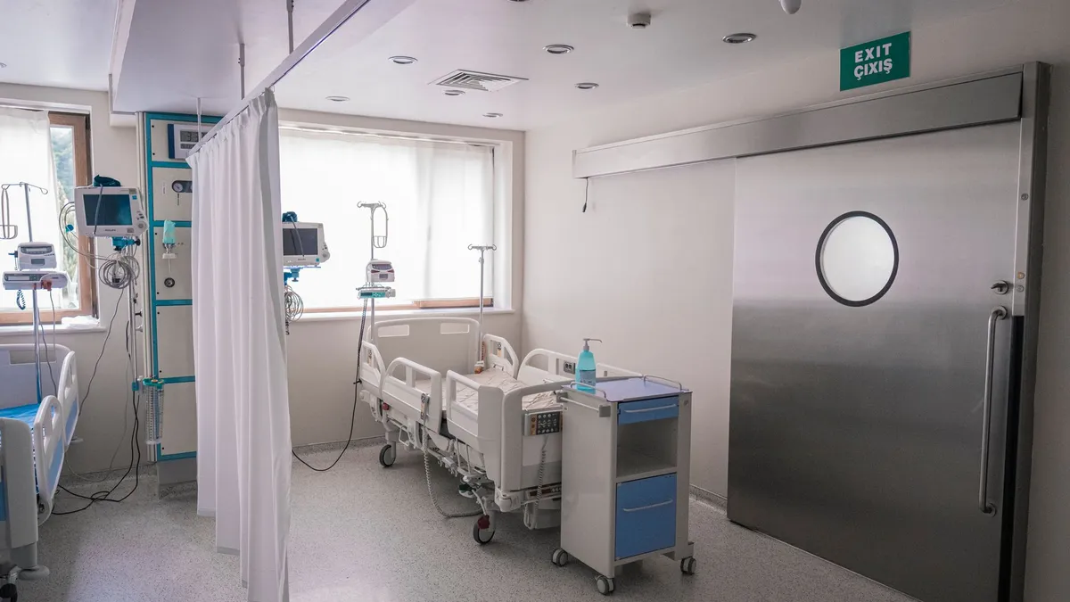 Gebürstete Edelstahlschiebetür mit rundem Sichtfenster in einem Behandlungsraum