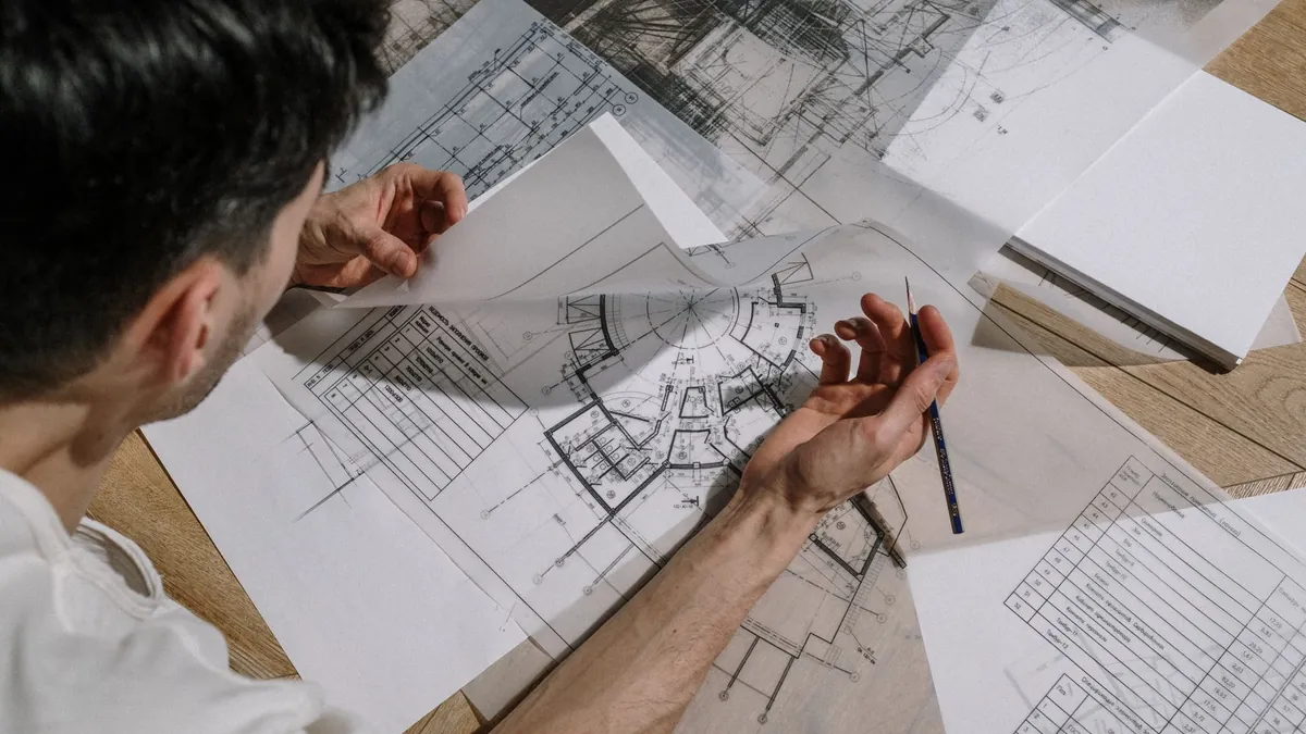 Buyer reviewing cleanroom door specification drawings and test reports at a desk