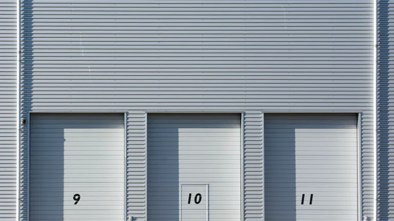 Row of numbered industrial roller doors on a factory facade ready for motorized operation