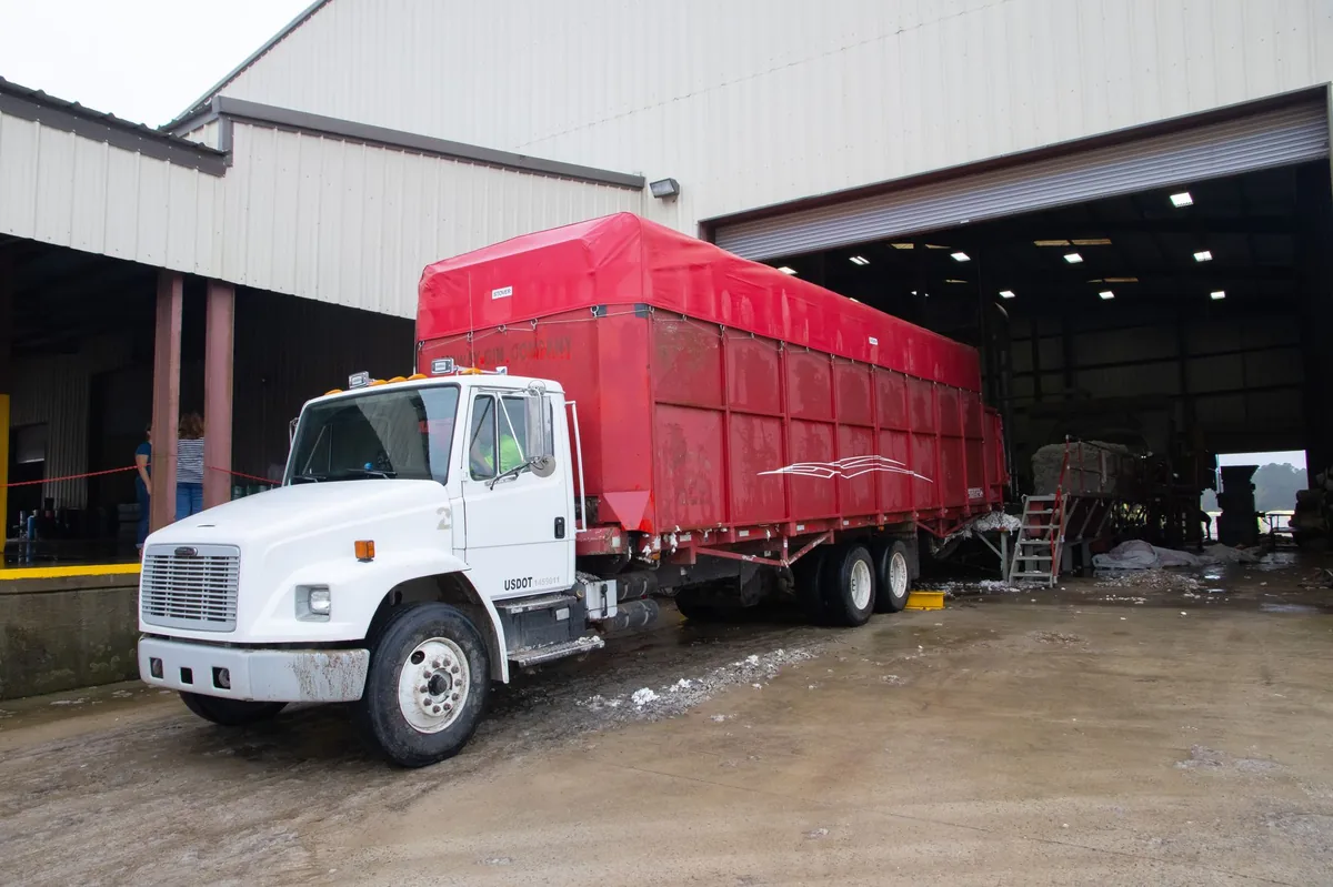 Red trailer truck waiting at a warehouse loading dock during the peak shift
