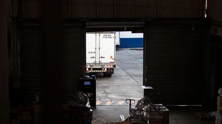 Industrial warehouse loading dock with trucks arriving for delivery