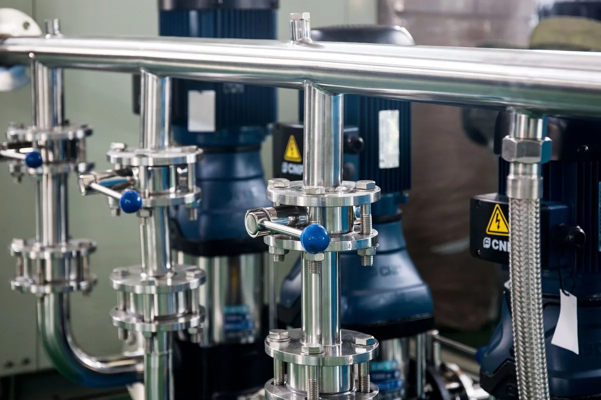 Polished stainless steel pipework and valve blocks in a hygienic processing plant