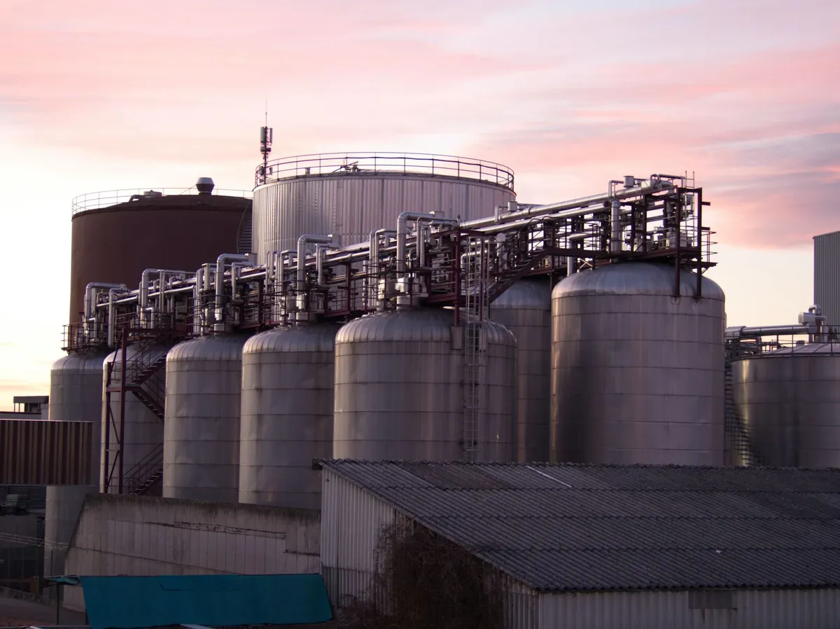 Chemical plant exterior with storage tanks, pipework and process equipment at sunset