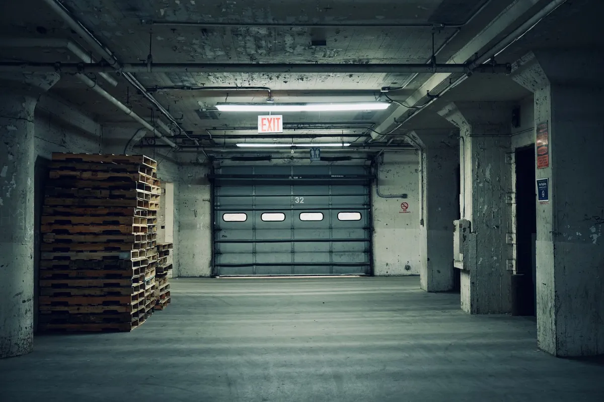Warehouse interior with pallets and a closed sectional door between shifts