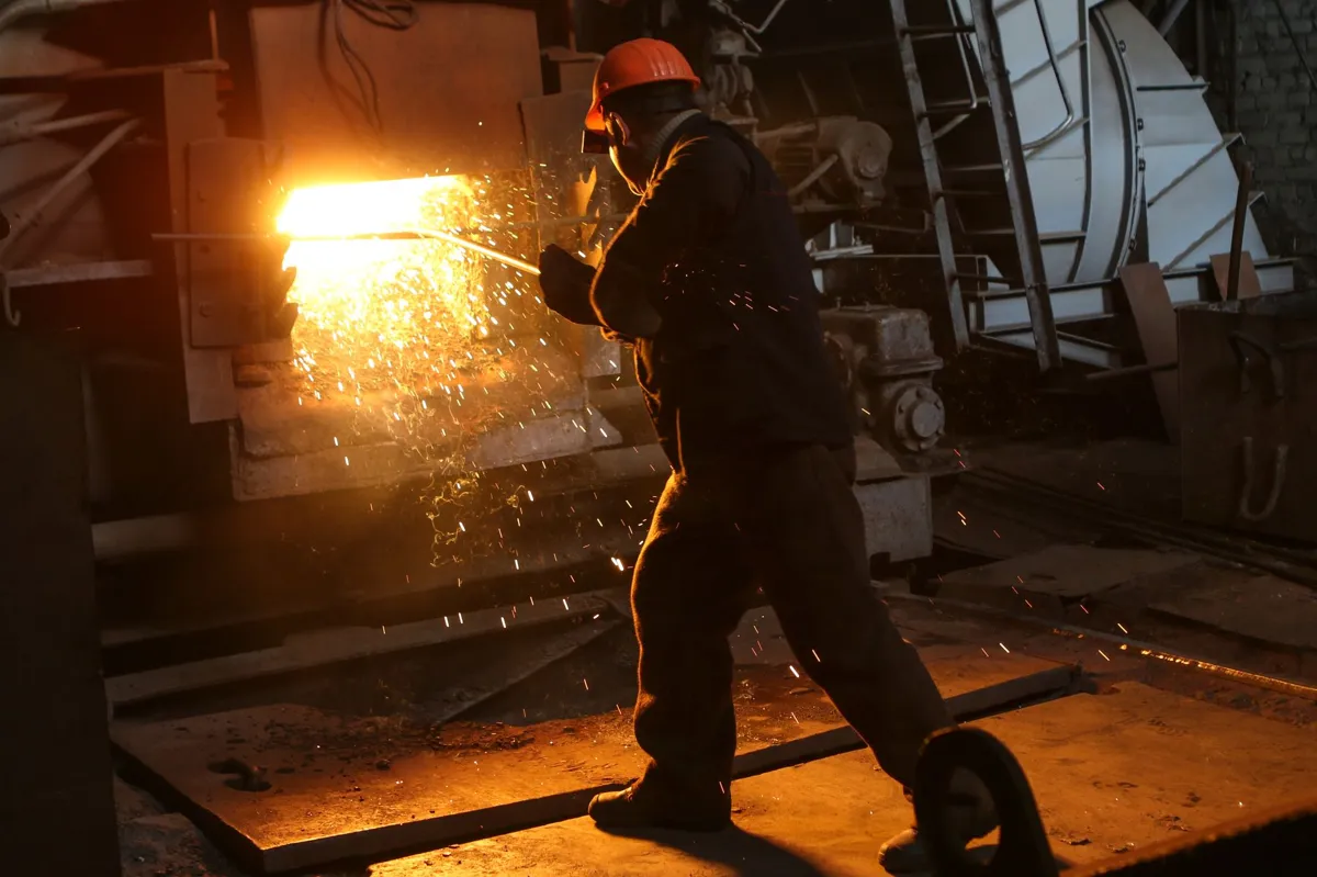 Sparks flying while welding an industrial door frame in a factory