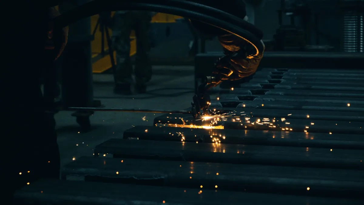 Worker cutting a steel sheet to verify industrial door quality