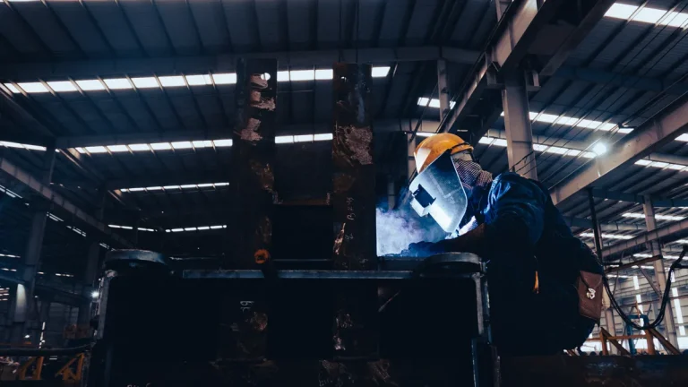 Welder assembling an industrial door frame in a factory workshop